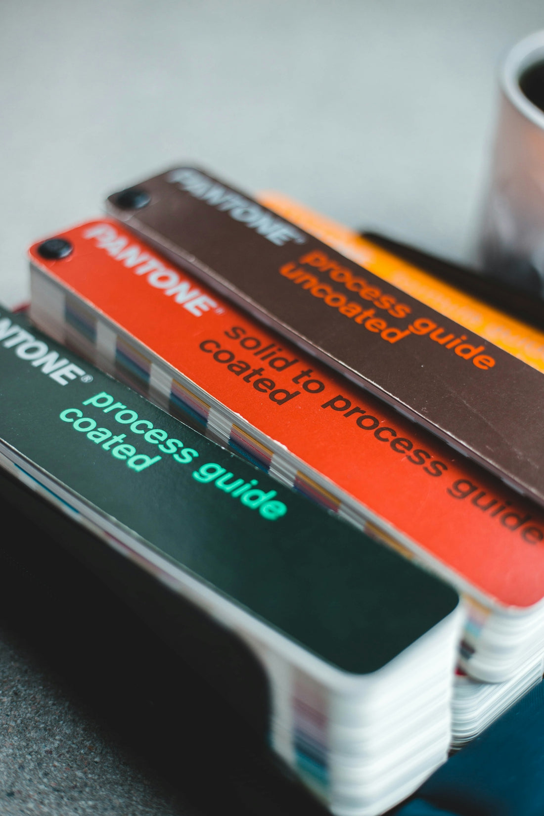 a stack of business cards sitting next to a cup of coffee