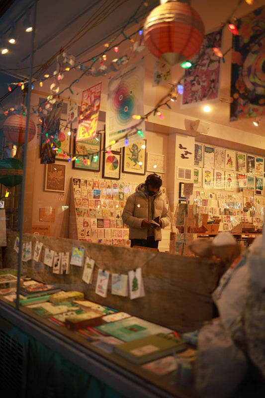Festive store interior with a person browsing displayed cards.